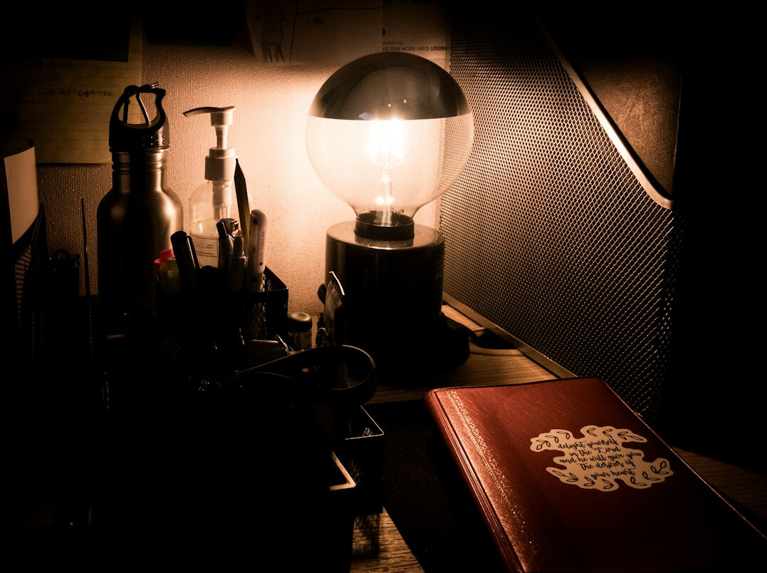 Escritorio de detective con libreta, lupa y documentos antiguos bajo luz tenue
